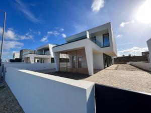 a modern house with a white wall at Luxury villas with heated pool & panoramic ocean & valley views in São Martinho do Porto