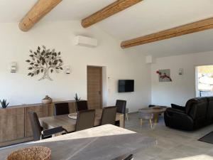 a living room with a table and a dining room at Le Mas No'Stelou in Pierrelongue