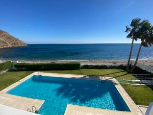 una piscina con el océano en el fondo en Apartamento Nautilus Beach, en Carboneras