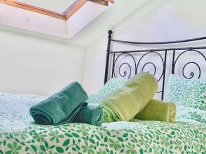 a bed with green blankets and pillows on it at Zorab&b in Breganzona