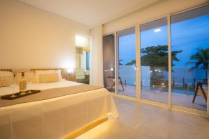 a bedroom with a bed and a view of the ocean at Village Someday in Arraial d'Ajuda +40 photos