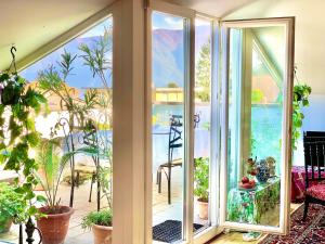 a room with glass doors and plants on a balcony at Zorab&b in Breganzona