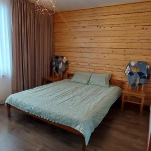 um quarto com uma cama e uma parede de madeira em Lauviņu rezidence em Kocēni