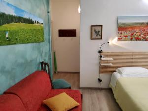 a bedroom with a bed and a red couch at Annadia Sweet Home B&B in Lido di Ostia