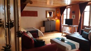 uma sala de estar com uma cama, um sofá e uma televisão em À Deux Pas ... em Briançon