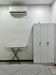 a white cabinet and a table in a room at Ali Homestay Sungai Petani in Sungai Petani +8 photos