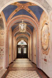 an ornate hallway in a building with a chandelier at Boutique Hotel Gaia in Kecskemét