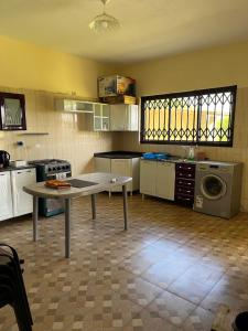 a kitchen with a table in the middle of it at CC House in Chidenguele