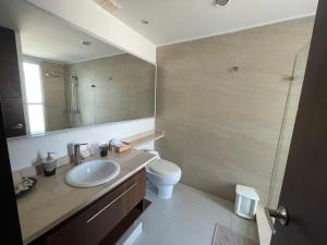 a bathroom with a sink and a toilet and a mirror at Cartagena Beach Front Apartments in Cartagena de Indias