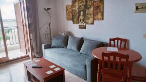a living room with a blue couch and a table at Costa Blanka resident apartman in Torrevieja