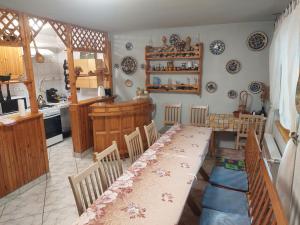 ein Esszimmer mit einem Tisch und einer Küche in der Unterkunft Ágnes Pihenőház in Szilvásvárad