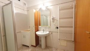uma casa de banho branca com um lavatório e um espelho em RomagnaBNB Stazione em Forlì