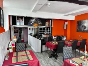 a restaurant with orange walls and tables and chairs at 36 Heritage House in Kington