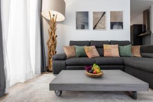 a living room with a couch and a bowl of fruit on a table at Pinzon Studios & Penthouse in Alicante