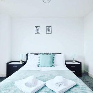 a bedroom with a bed with two towels on it at Yorksha Luxury Apartments Leeds in Leeds