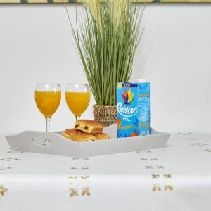 a tray with a drink and two glasses of orange juice at Yorksha Luxury Apartments Leeds in Leeds