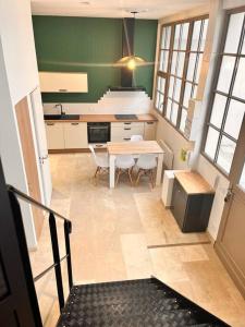 eine Küche mit einem Tisch und Stühlen sowie einem Tisch und einem Tisch in der Unterkunft Le loft Rousseau in Dijon