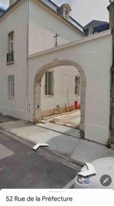 a white building with an archway in front of it at Le loft Rousseau in Dijon