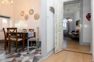 a dining room and living room with a table and chairs at Casa Dourada in Barcelos