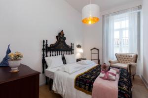 a bedroom with a bed with a doll sitting on it at Casa Dourada in Barcelos