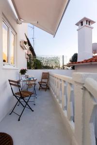 a balcony with chairs and a table on a wall at Casa Dourada in Barcelos