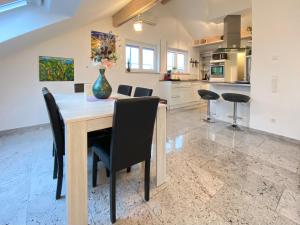 a kitchen and dining room with a table and chairs at 4 Zimmer Apartment, 125 qm, ruhig und zentrumsnah, max 5 Pers, Dachterasse, Garage, 1000 MBit in Böblingen
