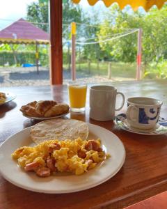 a table with a breakfast of eggs and toast and coffee at Casa Lemar in Quimbaya
