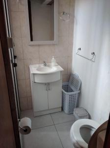 uma casa de banho com um lavatório, um espelho e um WC. em Novgorod em Aguas Dulces