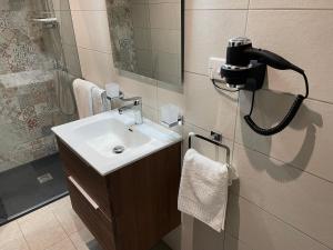 a bathroom with a sink and a camera on the wall at Spinola Bay Apt - Beatiful 3-Double Bed apt near beach in Prime Location in St Julian's