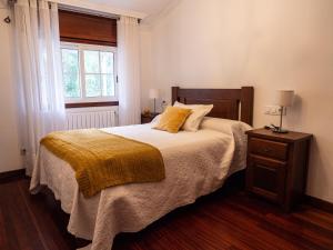 una camera da letto con un letto con una coperta gialla e una finestra di Casa Ramos a Vigo