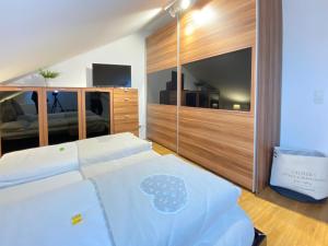1 dormitorio con 1 cama blanca grande y TV en 4 Zimmer Apartment, 125 qm, ruhig und zentrumsnah, max 5 Pers, Dachterasse, Garage, 1000 MBit, en Böblingen