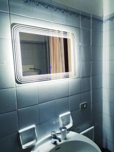 ein Bad mit einem Waschbecken und einem Spiegel in der Unterkunft Two steps from Rialto bridge in Venedig