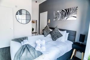 a bedroom with a white bed with a zebra picture on the wall at Chic Studio Apartment in Prime London Location in London