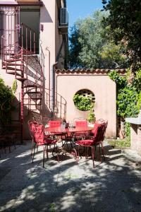 ヴェネツィアにあるSecret Gardenの建物前の赤いテーブルと椅子