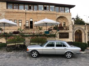 a car parked in front of a building with umbrellas at NOSTALJİ CAVE SUİT HOTEL in Nevşehir