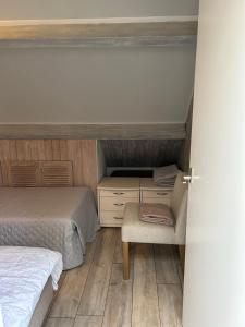 1 dormitorio pequeño con 2 camas y 1 silla en Apartment at the Beach, en Noordwijk