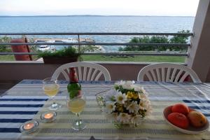 a table with a bottle of wine and flowers on it at Apartment Seaview, Rtina in Rtina