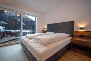 1 dormitorio con 1 cama grande y ventana grande en Apartment Villa Hetty, en Ortisei