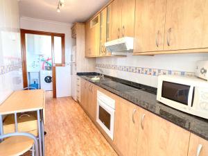 a kitchen with wooden cabinets and a counter top at Spanish Connection - Los Miradores del Puerto in La Manga del Mar Menor