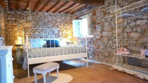 a bedroom with a bed in a stone wall at Agriturismo le Vallilunghe in Lucca