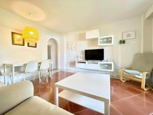 a living room with a couch and a tv at Residencial Alcaraván, Isla Canela - By AC REAL in Isla Canela