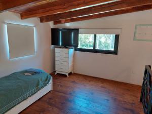ein Schlafzimmer mit einem Bett, einer Kommode und einem Fenster in der Unterkunft Santas Hogar in Santa Ana + 15 Fotos