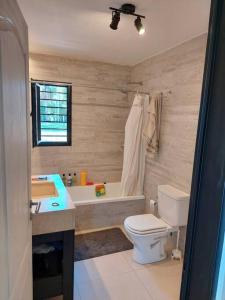 a bathroom with a toilet and a sink and a tub at Santas Hogar in Santa Ana