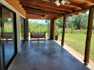a screened porch with a bench and a ceiling fan at Santas Hogar in Santa Ana