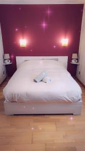 una camera da letto con un letto bianco e pareti viola di Au sable fin a Grand-Fort-Philippe