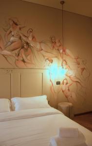 トリエステにあるLa Stazione degli Artistiの壁に女性画が描かれたベッドルーム