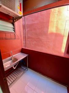 baño con lavabo y pared roja en Ratanawong Place 445 en Bangkok