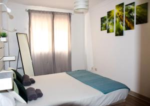 sypialnia z łóżkiem i dwoma obrazami na ścianie w obiekcie Blue waves - free parking w mieście El Médano