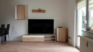 a living room with a flat screen tv on a white wall at Wohlfühlen in der Schifferstadt Roßlau in Dessau