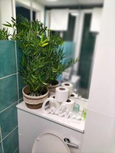 a bathroom with two potted plants and a mirror at Stylish London Studio l 1 Bd, 1 Bath Urban Retreat in London